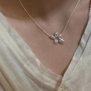 Elegant S925 sterling silver necklace featuring a minimalist flower pendant on a model