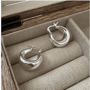 Detailed close-up of chunky S925 sterling silver hoop earrings with secure clasp in a box