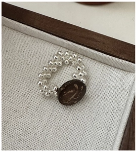 Detail of handcrafted S925 silver beaded ring featuring a rustic dark wood bead
