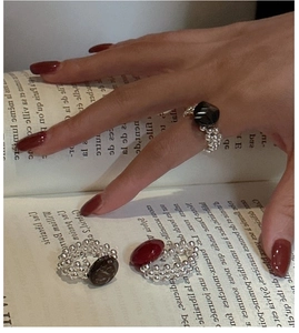 Detail of S925 silver beaded rings with dark oval stones on vintage French book pages