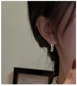Primo piano di una modella che indossa orecchini a fiore in argento S925 lucido