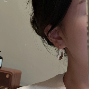 S925 sterling silver twisted hoop earrings with elegant spiral texture on female model