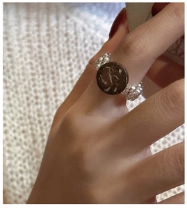 Detail of a vintage S925 silver beaded ring with a textured dark brown round centerpiece