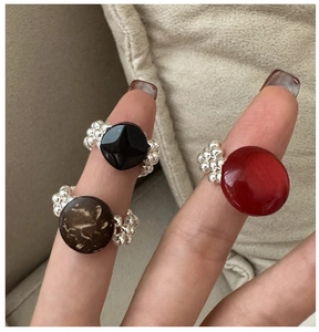 Detailed shot of handmade S925 silver beaded rings with black, brown, and red beads