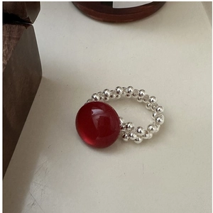 Detailed view of retro beaded ring with red agate gemstone and silver elastic band