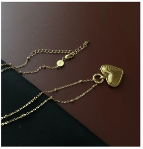Macro detail of S925 sterling silver gold heart pendant with textured vintage finish