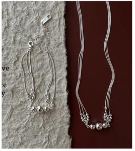 Macro detail of S925 sterling silver triple-layer beaded bracelet with AG925 hallmark tag