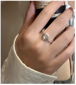 Detailed view of a silver donut ring featuring a lavender stone and wavy texture
