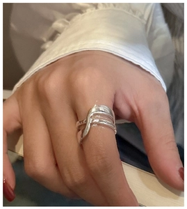 Dettaglio ravvicinato di un anello a doppio strato ondulato in argento S925 al dito