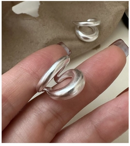 Gros plan sur une bague vague minimaliste en argent S925 avec une finition mate