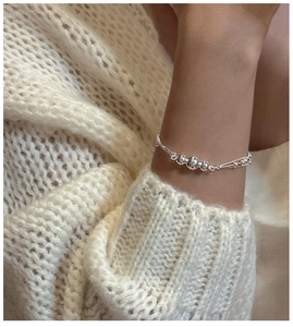 Macro shot of S925 sterling silver triple-layered bead bracelet on a female wrist
