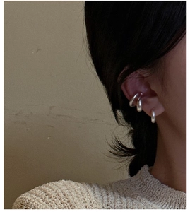 Gros plan de boucles d'oreilles minimalistes en argent S925 au fini mat sur modèle