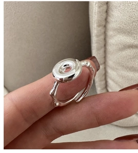 Macro shot of silver donut ring featuring organic fluid texture and polished finish