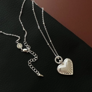 Minimalist S925 sterling silver heart pendant necklace with radiant texture on black leather