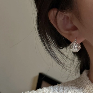 Minimalistische S925 Sterlingsilber Hohlkugel-Ohrringe getragen mit Strickpullover-Hintergrund