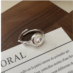 Macro detail of silver donut ring featuring organic branch texture and sparkling zircon