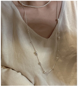 Detail of minimalist S925 silver adjustable chain necklace with metallic bead accents