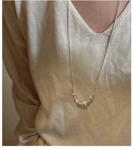 Detail of S925 sterling silver adjustable snake chain necklace worn on a V-neck sweater