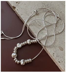 Detail of adjustable S925 sterling silver snake chain with textured metal beads