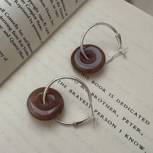 S925 sterling silver hoop earrings with vintage brown stone pendants on an open book