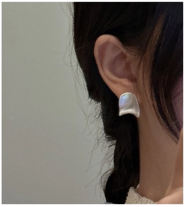 Nahaufnahme minimalistischer gebürsteter Silber-Ohrstecker getragen an einem Modell