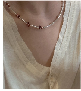 Close-up of handmade S925 silver beaded necklace with amber stones on a model