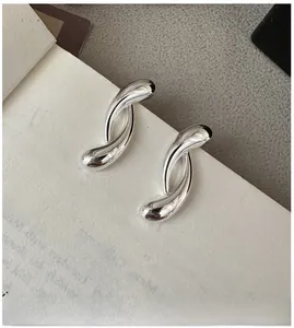 Close-up of S925 sterling silver crossover earrings with a high-polished mirror finish