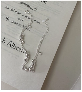 Detail of S925 sterling silver beaded bracelet with lobster clasp on vintage book