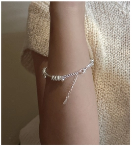 Detail of silver beaded chain bracelet with lobster clasp and teardrop charm
