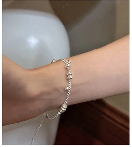 Close-up of minimalist S925 sterling silver chain bracelet with beads on female wrist