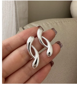 Detailed view of polished S925 sterling silver curved earrings with fluid geometric design