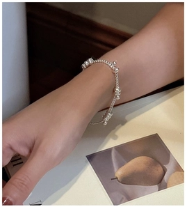 Close-up of minimalist S925 sterling silver beaded bracelet worn on wrist with polished finish