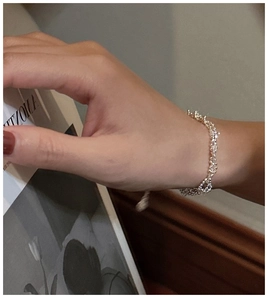 Detail of silver beaded chain bracelet on wrist with elegant lifestyle background