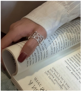 Detail of S925 sterling silver multilayer woven ring on a hand with magazine background