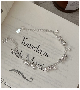 Close-up of S925 sterling silver beaded bracelet with lobster clasp on a book surface