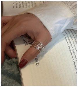Close-up of S925 sterling silver multilayer crisscross ring worn on thumb in retro style