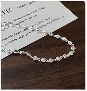 Macro shot of silver heart links with fine vertical textures on a stylish bracelet