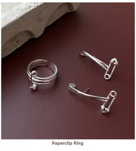 S925 silver safety pin heart ring and earrings set on red background texture