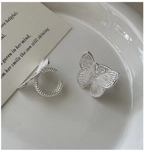 Detailed macro view of S925 sterling silver butterfly ear cuffs with textured wings