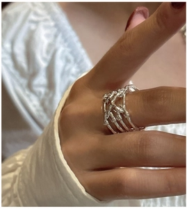 Detail of S925 sterling silver multilayer crisscross ring worn on a person's finger