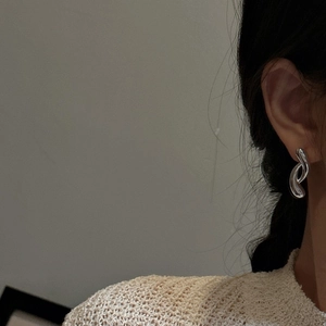 Minimalist S925 sterling silver crossed hoop earrings on model for a modern look