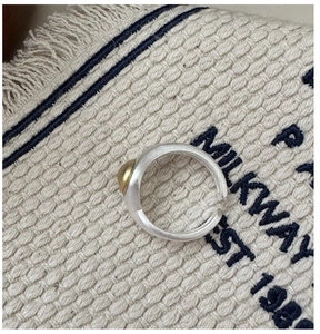 Detail of adjustable S925 silver ring featuring a matte finish and golden bead accent