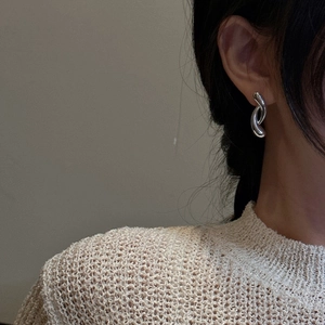 Minimalist S925 sterling silver crossover curved earrings worn by a model on her ear