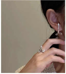 Detailed view of S925 sterling silver safety pin ring and earring on model