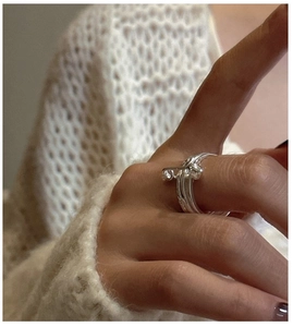 Detail of S925 sterling silver safety pin heart ring worn against a cozy knit sweater