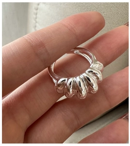 Macro view of a polished silver S925 sterling silver croissant style ring on hand