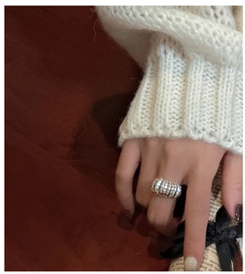 Close-up of S925 sterling silver croissant ring with stylish pleated texture on a finger
