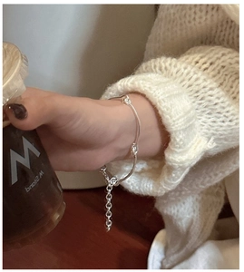 Detail of S925 sterling silver irregular link bracelet on wrist with coffee cup