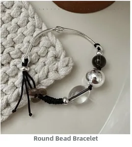 Macro shot of S925 silver beaded bracelet with woven rope and vintage floral charms