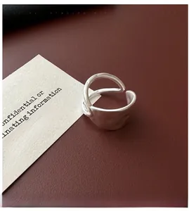 Detail view of silver double-layered ring with a hammered texture on a leather surface